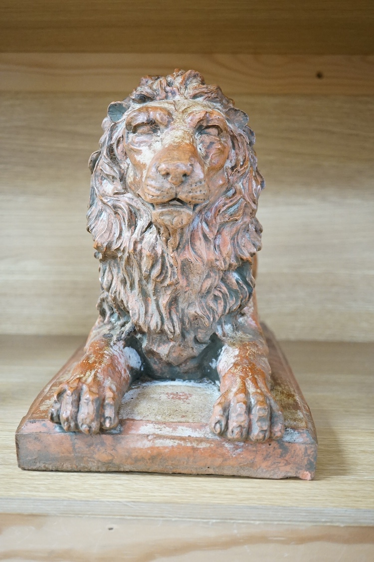 A terracotta sculpture of a lion, 39cm wide. Condition - good